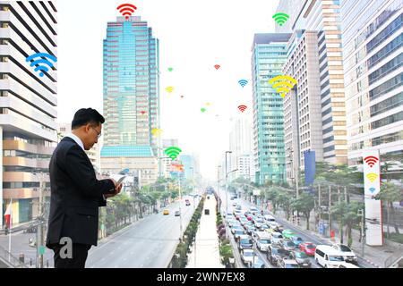 Geschäftsmann, der Mobiltelefone nutzt, kommunizieren über Inter-net-wlan, das viele Dienstanbieter in der Stadt hat Stockfoto