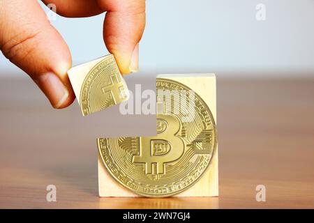 Hand hält Bit Münze Stichsäge, die auf Bit Münze Muster Stockfoto