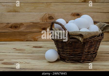 Frische weiße Hühnereier in einem Korb aus Holz. Das Konzept der Naturprodukte gesunde Lebensmittel Bio-Bauernhöfe. Welteiertag, osterferienkomposit Stockfoto