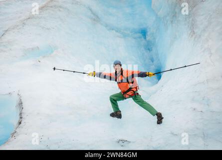 Ein Mann, der Wanderstöcke hält und Yoga macht, posiert vor einer Eisgrube. Nehmen Sie Die Abfahrt Glacier. Kenai Fjords National Park. Alaska. Stockfoto