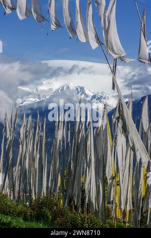 Malerischer vertikaler Blick auf die schneebedeckte Kangchenjunga-Bergkette durch buddhistische Gebetsfahnen und Banner in Pelling, Sikkim, Indien Stockfoto