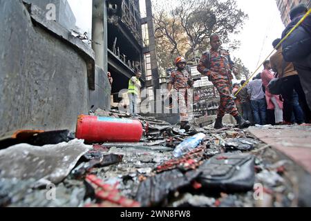 Dhaka, Wari, Bangladesch. März 2024. Einen Tag nach einem Brandunfall versammeln sich Menschen in der Nähe eines Geschäftsgebäudes, während Feuerwehrleute und forensische Experten am 1. März 2024 den Standort in Dhaka inspizieren. Die Feuerwehr in Bangladesch sagte am 1. März, dass die eklatanten Sicherheitsverstöße für eine Flamme im Restaurant Dhaka verantwortlich seien, bei der 45 Menschen getötet wurden, wobei unter denen, die in kritischem Zustand ins Krankenhaus kamen, wahrscheinlich mehr Todesfälle zu beklagen seien. (Kreditbild: © Habibur Rahman/ZUMA Press Wire) NUR REDAKTIONELLE VERWENDUNG! Nicht für kommerzielle ZWECKE! Stockfoto