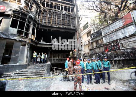 Dhaka, Wari, Bangladesch. März 2024. Einen Tag nach einem Brandunfall versammeln sich Menschen in der Nähe eines Geschäftsgebäudes, während Feuerwehrleute und forensische Experten am 1. März 2024 den Standort in Dhaka inspizieren. Die Feuerwehr in Bangladesch sagte am 1. März, dass die eklatanten Sicherheitsverstöße für eine Flamme im Restaurant Dhaka verantwortlich seien, bei der 45 Menschen getötet wurden, wobei unter denen, die in kritischem Zustand ins Krankenhaus kamen, wahrscheinlich mehr Todesfälle zu beklagen seien. (Kreditbild: © Habibur Rahman/ZUMA Press Wire) NUR REDAKTIONELLE VERWENDUNG! Nicht für kommerzielle ZWECKE! Stockfoto