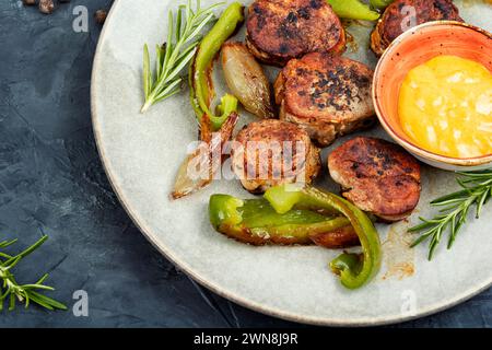 Saftige Fleischmedaillons mit gedünstetem Gemüse auf einem Teller. Stockfoto