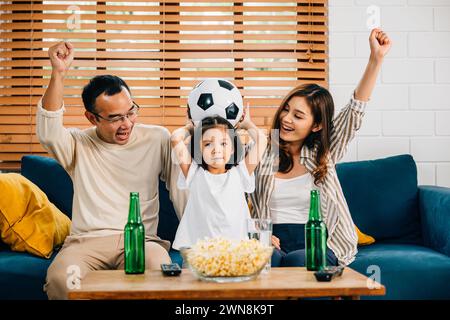 Eine glückliche Familie genießt den Nervenkitzel eines Fußballspiels zu Hause Stockfoto