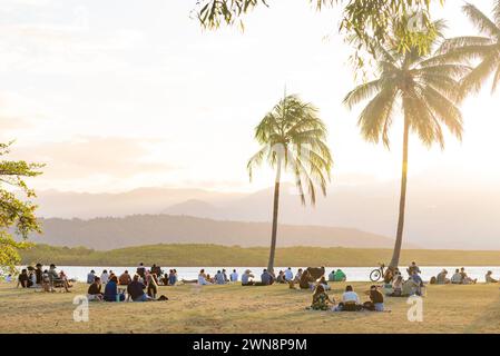 Am späten Nachmittag versammelten sich die Menschen in dem von Palmen gesäumten Park am Eingang zu Dixon Inlet und Port Douglas im Norden von Queensland, Australien Stockfoto