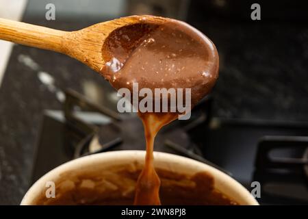 Eine Nahaufnahme eines hölzernen Löffels, der zur Herstellung von selbstgemachtem Schokoladen-Brigadeiro verwendet wurde Stockfoto