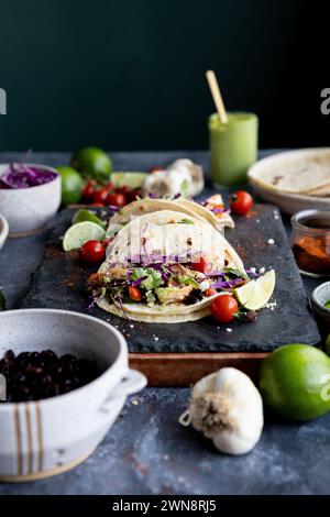 Blick auf Augenhöhe auf Tacos auf dunklem Hintergrund mit farbenfrohen Zutaten Stockfoto