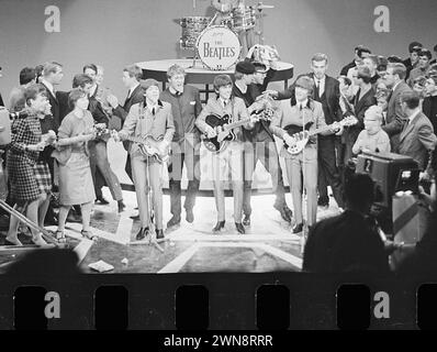 Amsterdam, Niederlande. Juni 1964. Fernsehaufführung der Beatles in Treslong te Hillegom. Mit Fans um George Harrison, Paul McCartney und John Lennon auf der Bühne Stockfoto