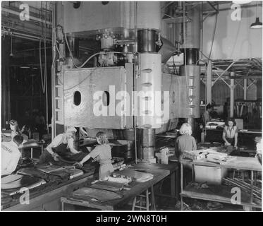 Vintage-Fotografien von Frauen, die im Zweiten Weltkrieg in Fabriken arbeiten, Teil des wichtigen Beitrags der Frauen zu den Kriegsanstrengungen. Frauen übernehmen den Betrieb einiger der schwersten Werkzeugmaschinen im Werk von North American Aviation, Inc. In Inglewood, Kalifornien Tag und Nacht verwenden Schichten von Mädchen diese riesige Hydraulikpresse, um Tausende von Blechteilen für Kriegsflugzeuge der Vereinten Nationen zu Formen. Oktober 1942 Stockfoto