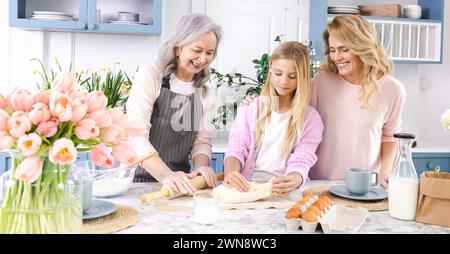 Oma, Mom und Enkelin genießen gute Zeit zusammen, während sie in einer wunderschönen Küche Teig machen. familienverband von Frauen verschiedener Generationen Stockfoto