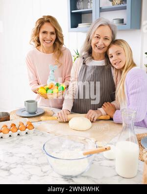 Frohe Ostern. Frauen von drei Generationen machen Osterkuchen und Feiertagsessen in gemütlicher Küche Stockfoto