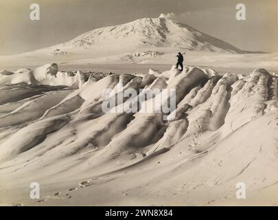 Vintage-Antarktis-Fotografie von Herbert George Ponting um 1911. Mount Erebus über einem wasserabgenutzten Eisberg Stockfoto