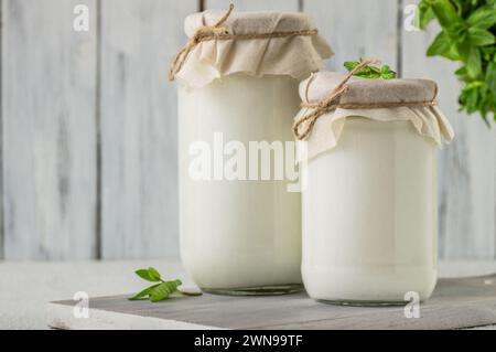 Hausgemachter Joghurt mit Creme im Glas auf weißem rustikalem Tisch, gesundes Essen Stockfoto