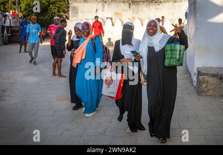 Eine Gruppe verhüllter junger muslimischer Frauen in Buibui-Gewändern in Stone Town, Sansibar, Tansania Stockfoto