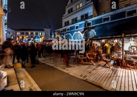 Die Leute schlendern durch einen Markt mit Holzständen und hellen Lichtern bei Nacht, den Weihnachtsmarkt Dresden Stockfoto