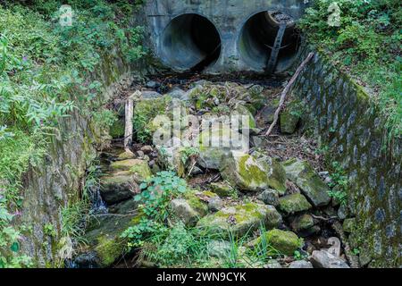 Doppelter Düker am Ende eines von Menschen geschaffenen Grabens, gefüllt mit großen Felsbrocken in Südkorea Stockfoto