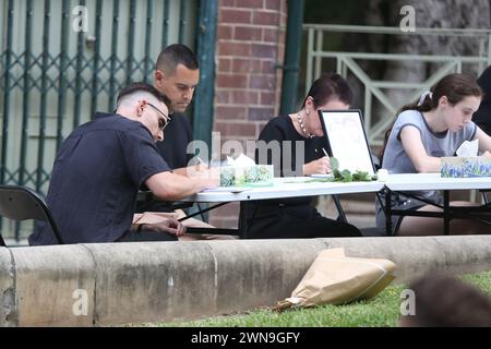 Sydney, Australien. März 2024. Hunderte haben sich in Green Park, Darlinghurst, versammelt, um dem angeblich ermordeten Sydney-Paar Jesse Baird und Luke Davies am Vorabend der Mardi Gras-Parade zu Tribut zu zollen. Die Leute standen an, um ein Beileidsbuch zu unterschreiben, und saßen still. Einige Musik wurde abgespielt, während die beiden auf einer Großleinwand gezeigt wurden. Richard Milnes/Alamy Live News Stockfoto