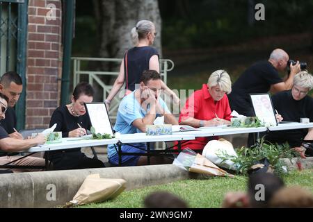 Sydney, Australien. März 2024. Hunderte haben sich in Green Park, Darlinghurst, versammelt, um dem angeblich ermordeten Sydney-Paar Jesse Baird und Luke Davies am Vorabend der Mardi Gras-Parade zu Tribut zu zollen. Die Leute standen an, um ein Beileidsbuch zu unterschreiben, und saßen still. Einige Musik wurde abgespielt, während die beiden auf einer Großleinwand gezeigt wurden. Richard Milnes/Alamy Live News Stockfoto