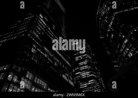 Eindrucksvolle abstrakte, monochrome Architekturlandschaft mit Wolkenkratzer-Büros, beleuchtet bei Nacht auf dem Bishopsgate in der Nähe der Liverpool Street in der City of London. Stockfoto