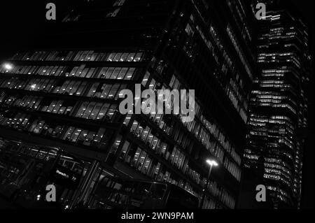 Eindrucksvolle abstrakte, monochrome Architekturlandschaft mit Wolkenkratzer-Büros, beleuchtet bei Nacht auf dem Bishopsgate in der Nähe der Liverpool Street in der City of London. Stockfoto