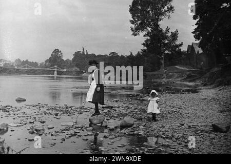 1897 Historisches Schwarzweißfoto eines Nanny and Child am River Wye mit Victoria Bridge, Hereford, Herefordshire, England, Großbritannien Stockfoto