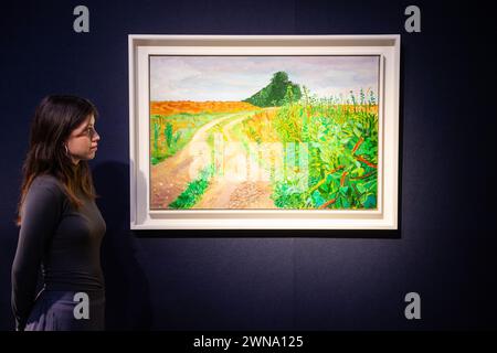 London, England, Großbritannien. März 2024. Christies Mitarbeiter betrachtet David Hockneys „Rudston to Sledmere, August“, die auf 2.000.000 bis 3.000.000 GBP geschätzt wurde, während der Pressevorschau von Christies „20th/21st Century London Evening Sale“ und „The Art of the Surreal Evening Sale“. Der Verkauf findet am Abend des 7. März statt. (Kreditbild: © Thomas Krych/ZUMA Press Wire) NUR REDAKTIONELLE VERWENDUNG! Nicht für kommerzielle ZWECKE! Stockfoto