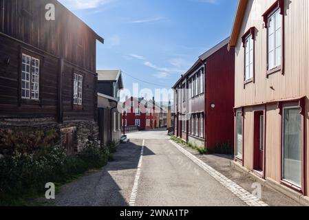 Eine sonnendurchflutete Straße in Roros bietet einen Einblick in die norwegische Geschichte mit ihren farbenfrohen Holzfassaden und der friedlichen Stadtlandschaft Stockfoto