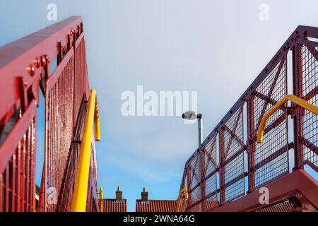 Neue (teilweise restaurierte) Fußgängerbrücke in traditionellem Rot an einem hellen Tag unter blauem Himmel am alten und historischen Bahnhof Beverley, Großbritannien. Stockfoto