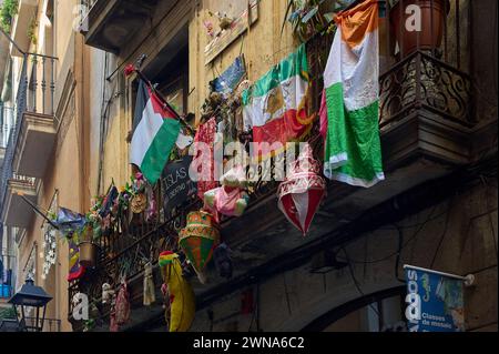 Ein städtischer Balkon mit mexikanischen Flaggen und traditioneller Dekoration in einer engen Gasse in der Stadt Barcelona in Katalonien Stockfoto