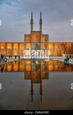 Takyeh (Gebäude, in dem sich schiitische Muslime versammeln, um Husayns Tod zu betrauern) und Minarette des Amir-Chakhmaq-Komplexes spiegeln sich in einem Wasserbecken. Yazd, Iran. Stockfoto