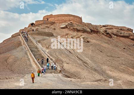 Touristen gehen die Treppe hinunter nach dem Besuch des Turms der Stille (Dakhmeh), einer Struktur, die in der zoroastrischen Begräbnistradition verwendet wurde. Yazd, Iran. Zoroastr Stockfoto