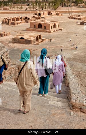 Touristen gehen eine Steintreppe hinunter, nachdem sie den Turm der Stille (Dakhmeh) besucht haben, eine Struktur, die in der zoroastrischen Begräbnistradition verwendet wurde. Yazd, Iran. Zoroast Stockfoto