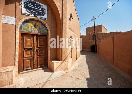 Hölzerne Eingangstür des alten Hauses der Rafiäer (heute beherbergt die Yazd Touristenbibliothek) im historischen Fahadan Viertel Yazd, Iran. Stockfoto