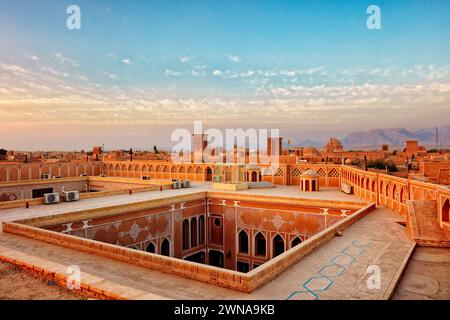 Blick von der Dachterrasse auf traditionelle lehmziegelgebäude im historischen Viertel Fahadan bei Sonnenuntergang. Yazd, Iran. Stockfoto