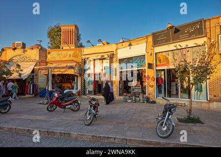 Sonnendurchflutete Fassaden zahlreicher Souvenirläden entlang der Masjed Jame’ Street im historischen Zentrum von Yazd, Iran. Stockfoto