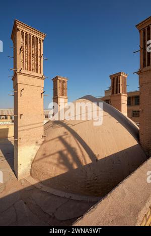 Das Kuppeldach und die Windfänger (traditionelle Türme zur Querbelüftung und passiven Kühlung) des alten Golshan Wasserreservoirs in Yazd, Iran. Stockfoto