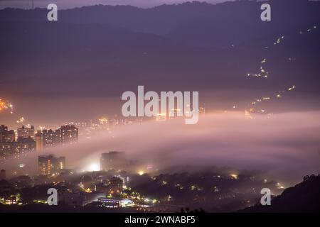 Wolken und Nebel ziehen über die Stadt, und das bunte glasierte Licht leuchtet. Genießen Sie den Sonnenuntergang und das Wolkenmeer. Zhongzhengshan Wander Trail, Taipeh Stadt Stockfoto