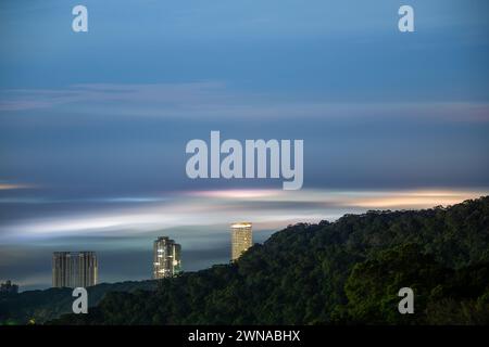 Wolken und Nebel ziehen über die Stadt, und das bunte glasierte Licht leuchtet. Genießen Sie den Sonnenuntergang und das Wolkenmeer. Zhongzhengshan Wander Trail, Taipeh Stadt Stockfoto