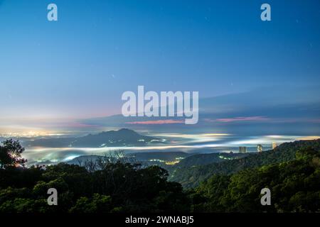 Wolken und Nebel ziehen über die Stadt, und das bunte glasierte Licht leuchtet. Genießen Sie den Sonnenuntergang und das Wolkenmeer. Zhongzhengshan Wander Trail, Taipeh Stadt Stockfoto