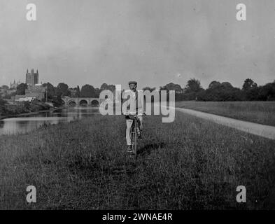 1901 Historisches Schwarzweißfoto eines Radfahrers auf der Bishops Meadow am River Wye und der Wye Bridge & Cathedral, Hereford, Herefordshire, England, Großbritannien Stockfoto