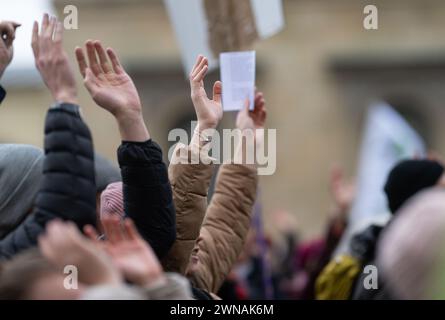 München, Deutschland. März 2024. Demonstranten heben während eines von Fridays for Future und Verdi initiierten Klimastreiks im Rahmen der #Wirfahrenzusammen-Kampagne auf dem Odeonsplatz die Hände in die Luft. Quelle: Lukas Barth/dpa/Alamy Live News Stockfoto