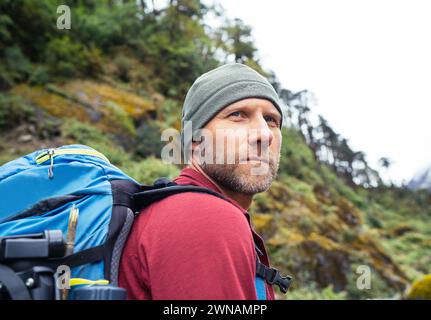 Porträt eines kaukasischen Mannes mit Rucksack auf der Makalu Barun Park Route in der Nähe von Khare. Mera Peak Klettern Akklimatisierung aktiv Walk. Backpacker genießt val Stockfoto