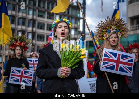 Ukrainer und Unterstützer führen einen massenprotestionsmarsch durch das Zentrum Londons durch, um sich am 2. Jahrestag der russischen Invasion auf dem Trafalgar-Platz zu versammeln Stockfoto