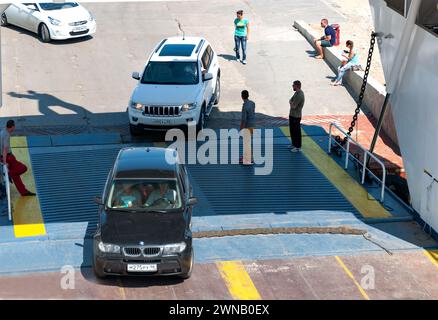 Juni 2015 Russland Port Kavkaz. Verladung von Autos auf eine Fähre an einem Sommertag. Fahrzeuge werden auf eine Autofähre geladen. Stockfoto