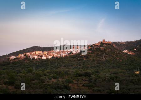 Landschaft der historischen Stadt Villafames umgeben von Bäumen bei Sonnenuntergang mit der Burg auf dem Hügel, Castellon, Spanien Stockfoto