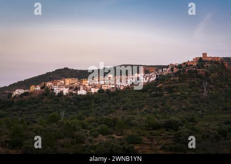 Landschaft der historischen Stadt Villafames umgeben von Bäumen bei Sonnenuntergang mit der Burg auf dem Hügel, Castellon, Spanien Stockfoto