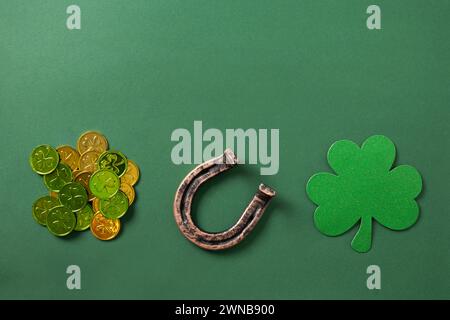 St. Patrick's Day Komposition mit Kleeblatt und Hufeisen auf grünem Hintergrund. Blick von oben. Kopierbereich. Stockfoto