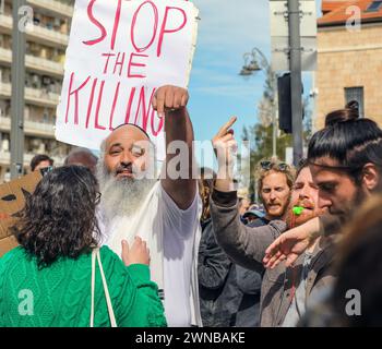 Jerusalem, Israel. März 2024. Teilnehmer an einer Demonstration, in der Israel aufgefordert wird, den Krieg mit der Hamas in Gaza zu beenden. Ein Mann, der gegen die Demonstration spricht (d. h. der die Regierung unterstützt), der mit einem Demonstranten streitet. Hinter ihm steht ein Zeichen: "Stoppt das Töten". Um ihn herum sind viele Demonstranten. Quelle: Yoram Biberman/Alamy Live News. Stockfoto