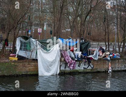 Berlin, Deutschland. Januar 2024. 15.01.2024, Berlin. Obdachlose haben sich trotz der winterlichen Temperaturen aus Plastikfolien, Müll und den Überresten eines alten Hauszelt am Ufer des Landwehrkanals einen provisorischen Unterschlupf gebaut. In der Hauptstadt gibt es nun immer mehr solche informellen Zeltgebäude und Hütten. Obdachlose Alkoholiker oder mehrfache Süchtige aus Osteuropa leben in vielen von ihnen ohne Strom, fließendes Wasser oder Kanalisation, oft monatelang. Kredit: Wolfram Steinberg/dpa Kredit: Wolfram Steinberg/dpa/Alamy Live News Stockfoto